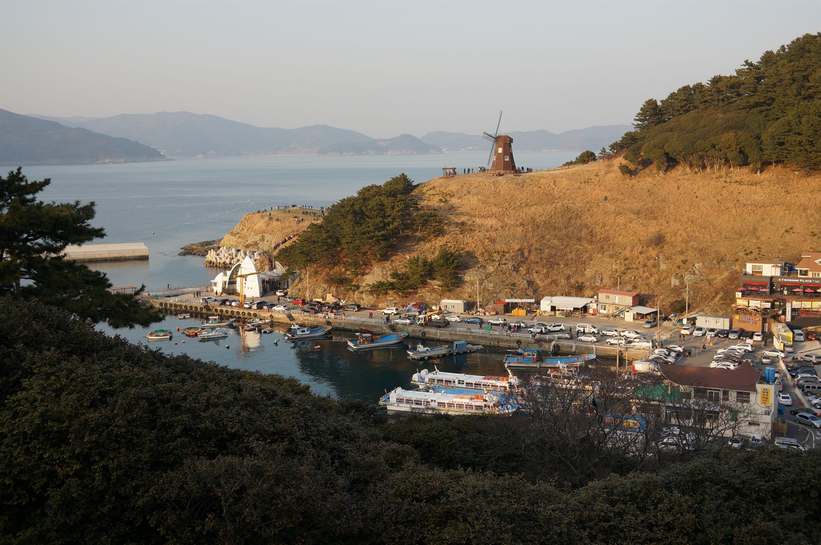 도장포항과 바람의 언덕 풍차. 해금강 유람선이 정박해 있습니다