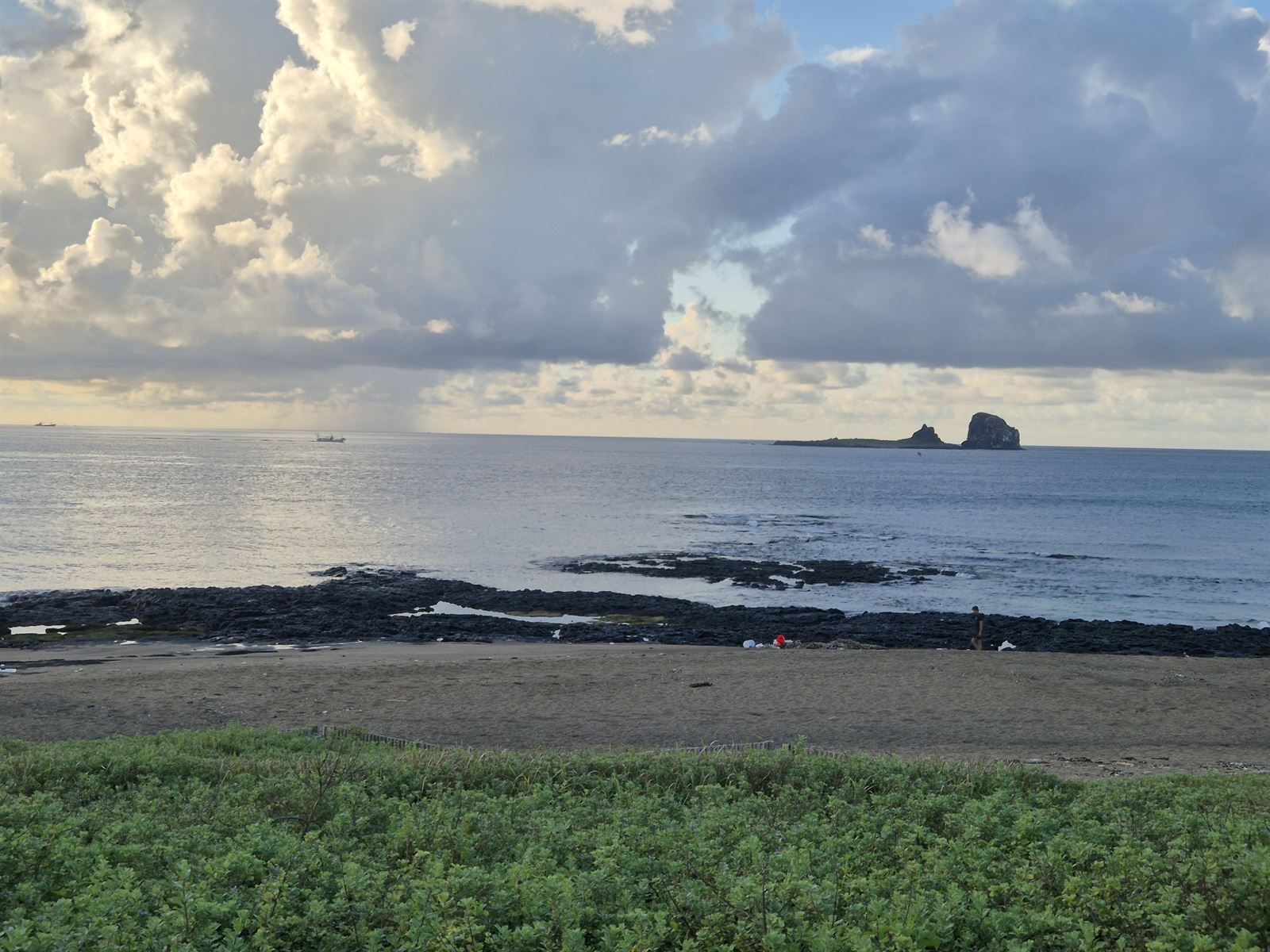 형제섬 — 검은 현무암 갯바위 너머, 바다에 붙어 있는 두 개의 작은 섬