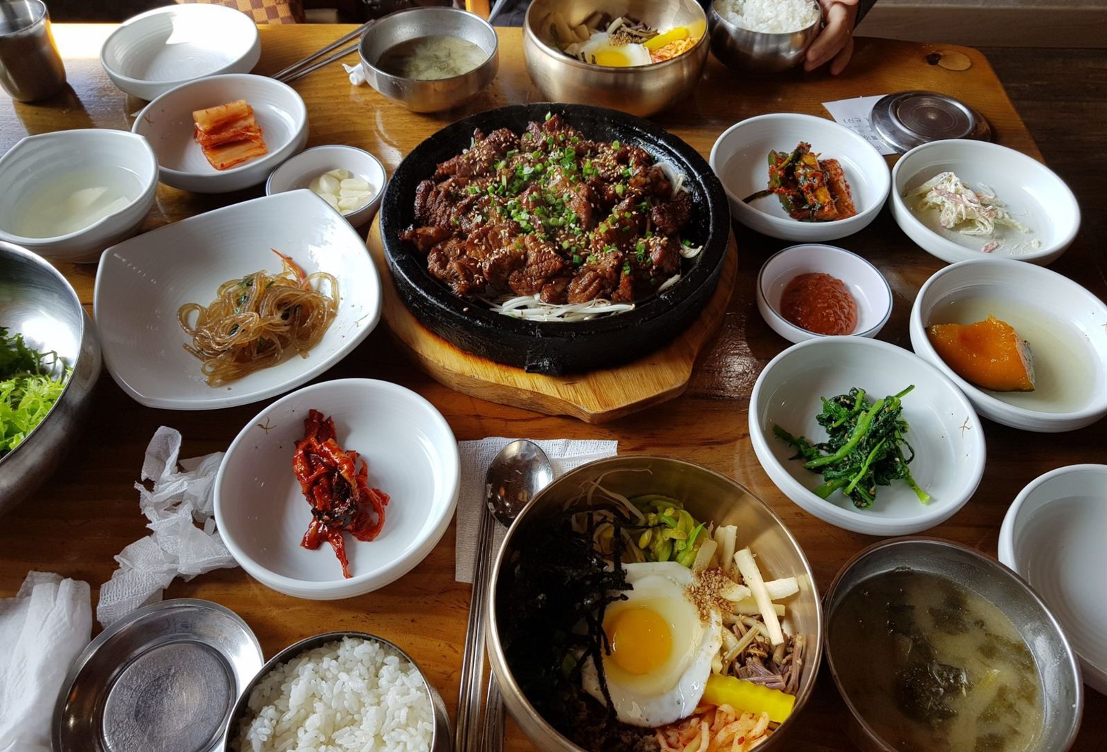 교동석갈비의 상차림 — 돌판 석갈비를 중심으로 십수 가지 반찬이 둘러싼 모습